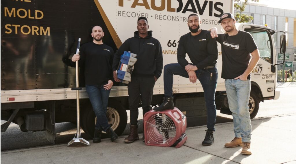 Team from Paul Davis Restoration of Central Connecticut standing in front of service truck with professional equipment, ready to handle restoration services